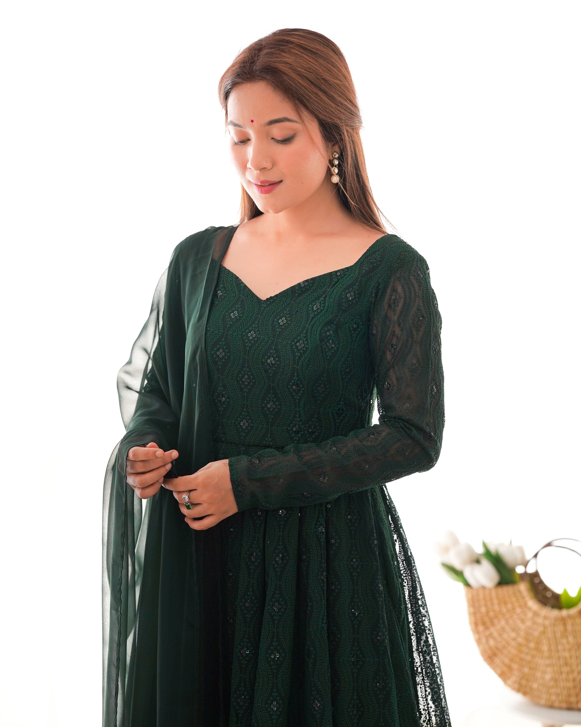 Woman wearing a green traditional outfit with a white background