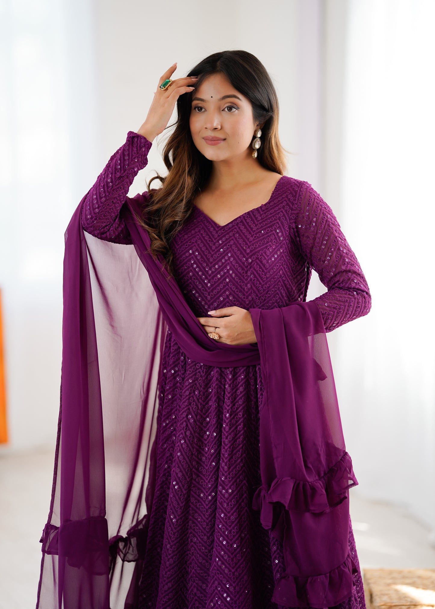 Woman wearing a purple traditional outfit with a white background