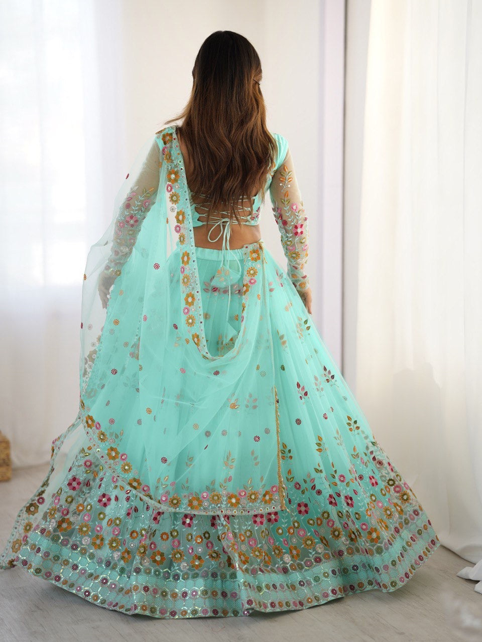 Light blue embroidered traditional outfit with a sheer dupatta on a white background