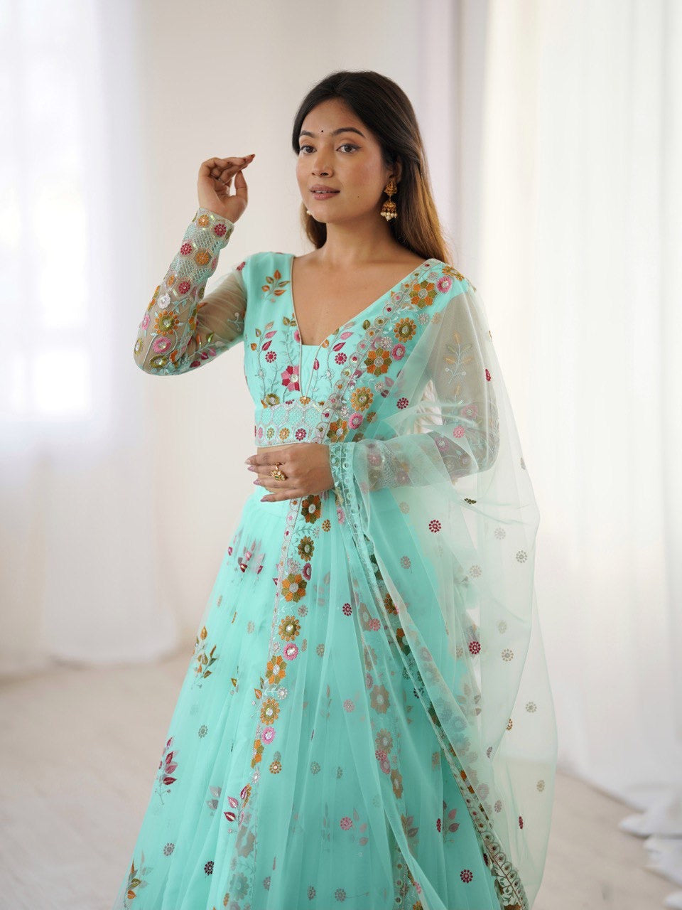 Woman wearing a light blue floral saree with a white background