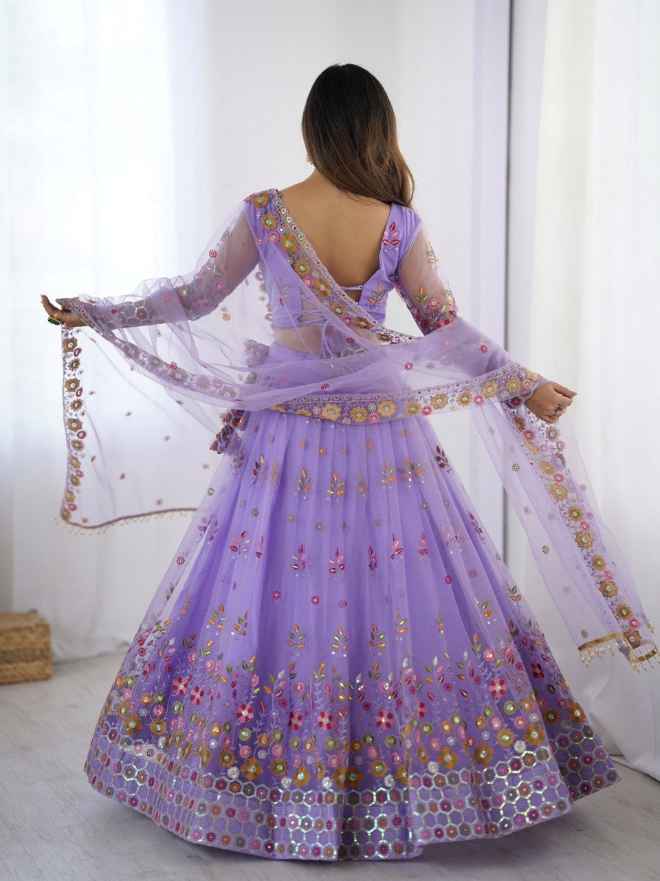 Woman wearing a purple embroidered traditional outfit with a white background