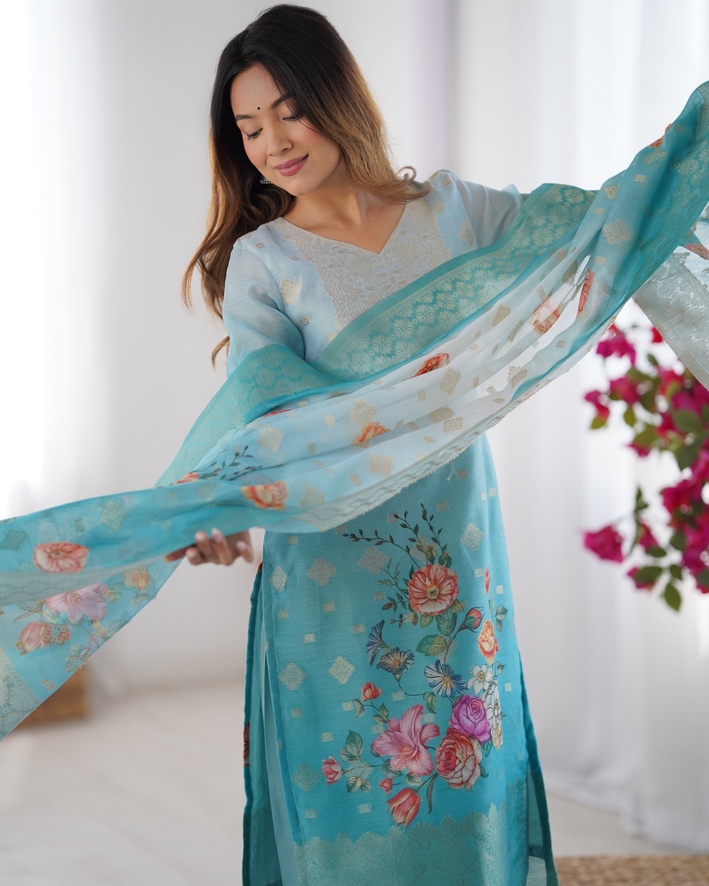 Woman holding a floral-patterned blue scarf with a blurred background