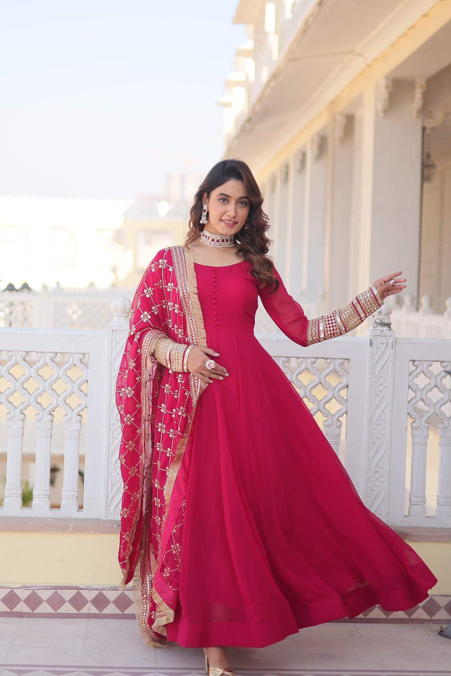 Woman in a red traditional outfit standing on a decorative staircase.