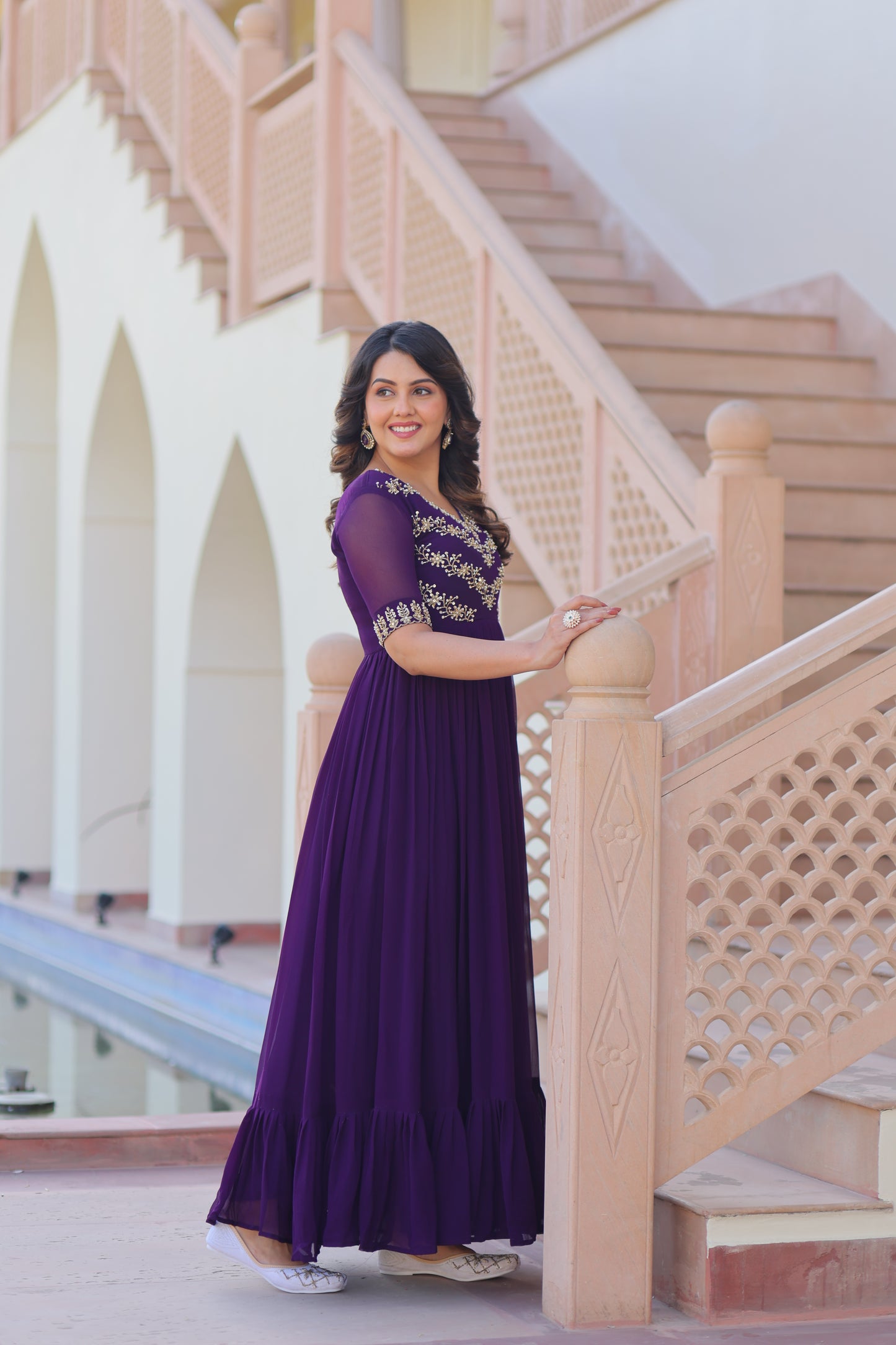 Woman in a purple dress standing on a staircase