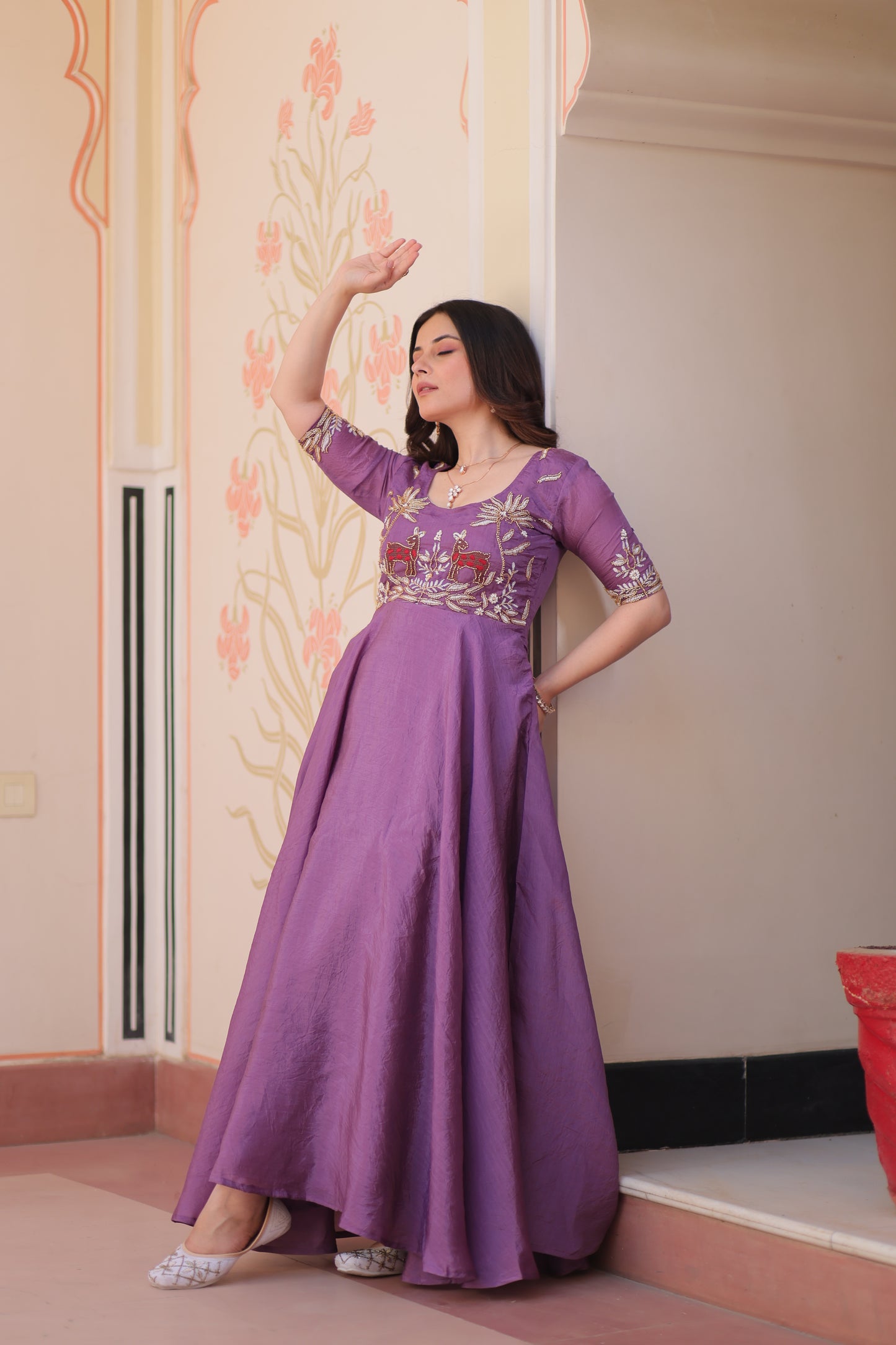 Woman in a purple dress lying on a bed with floral patterns