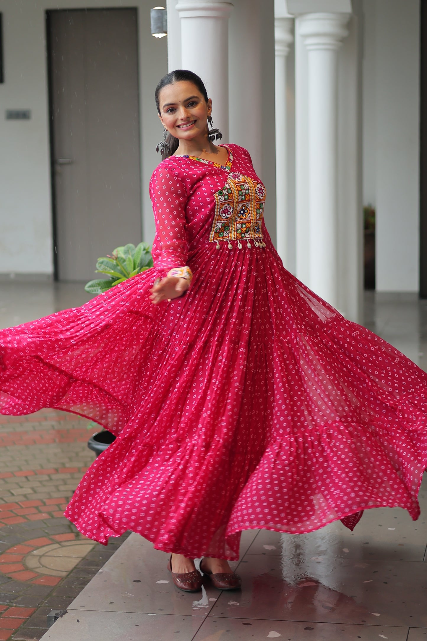 Woman in a red traditional outfit with a patterned top in an indoor setting