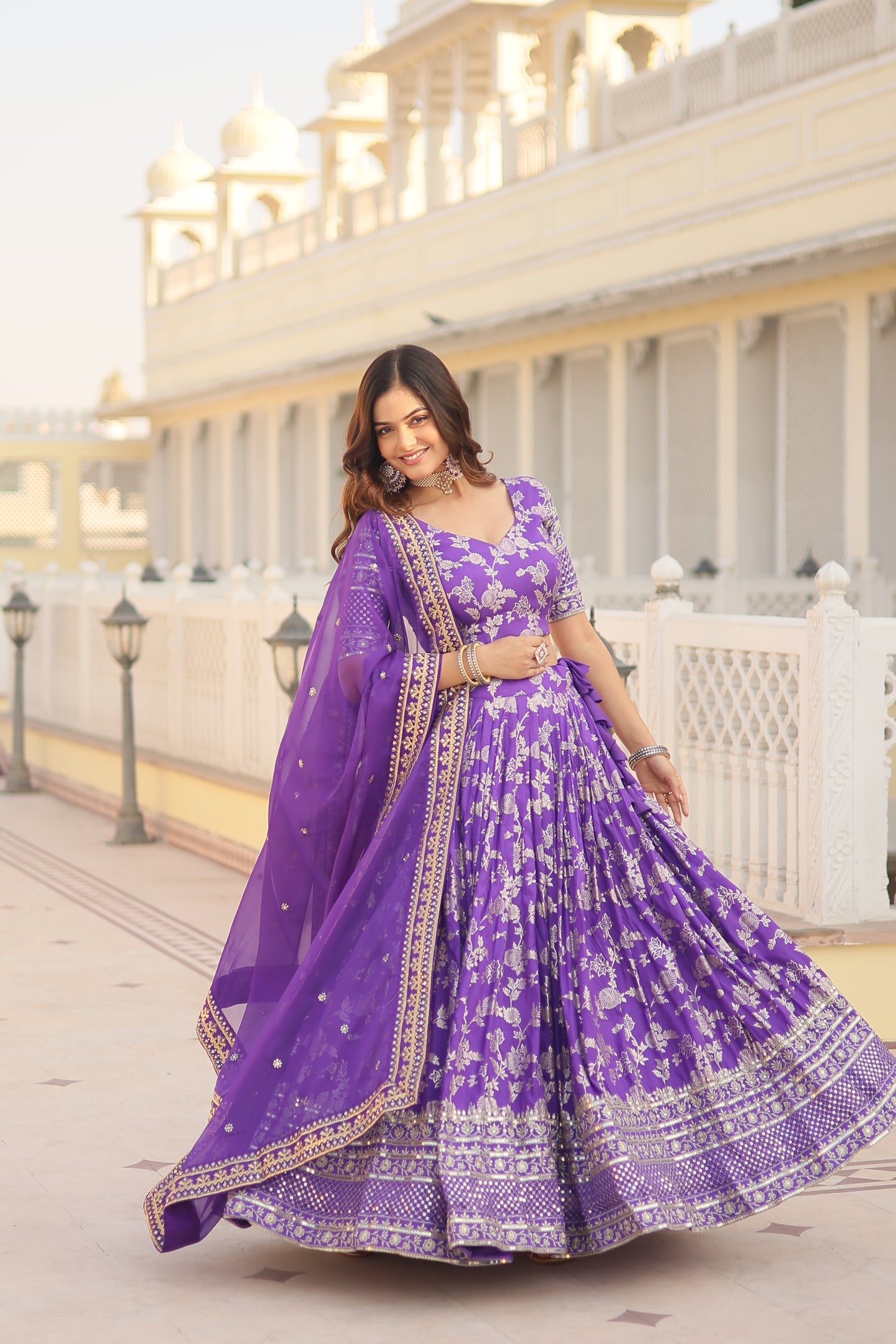 Woman in a purple traditional outfit standing on a staircase.
