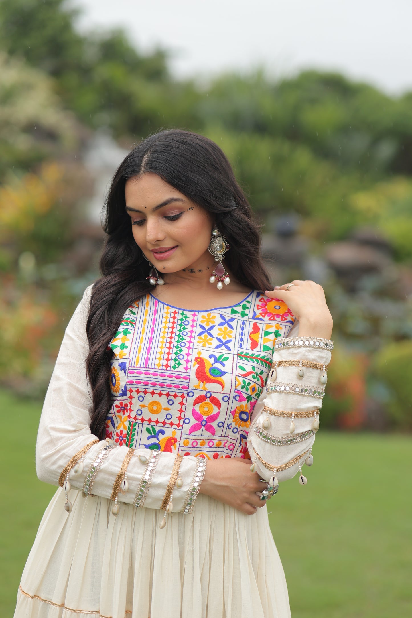 Woman wearing a traditional embroidered blouse with a blurred green background