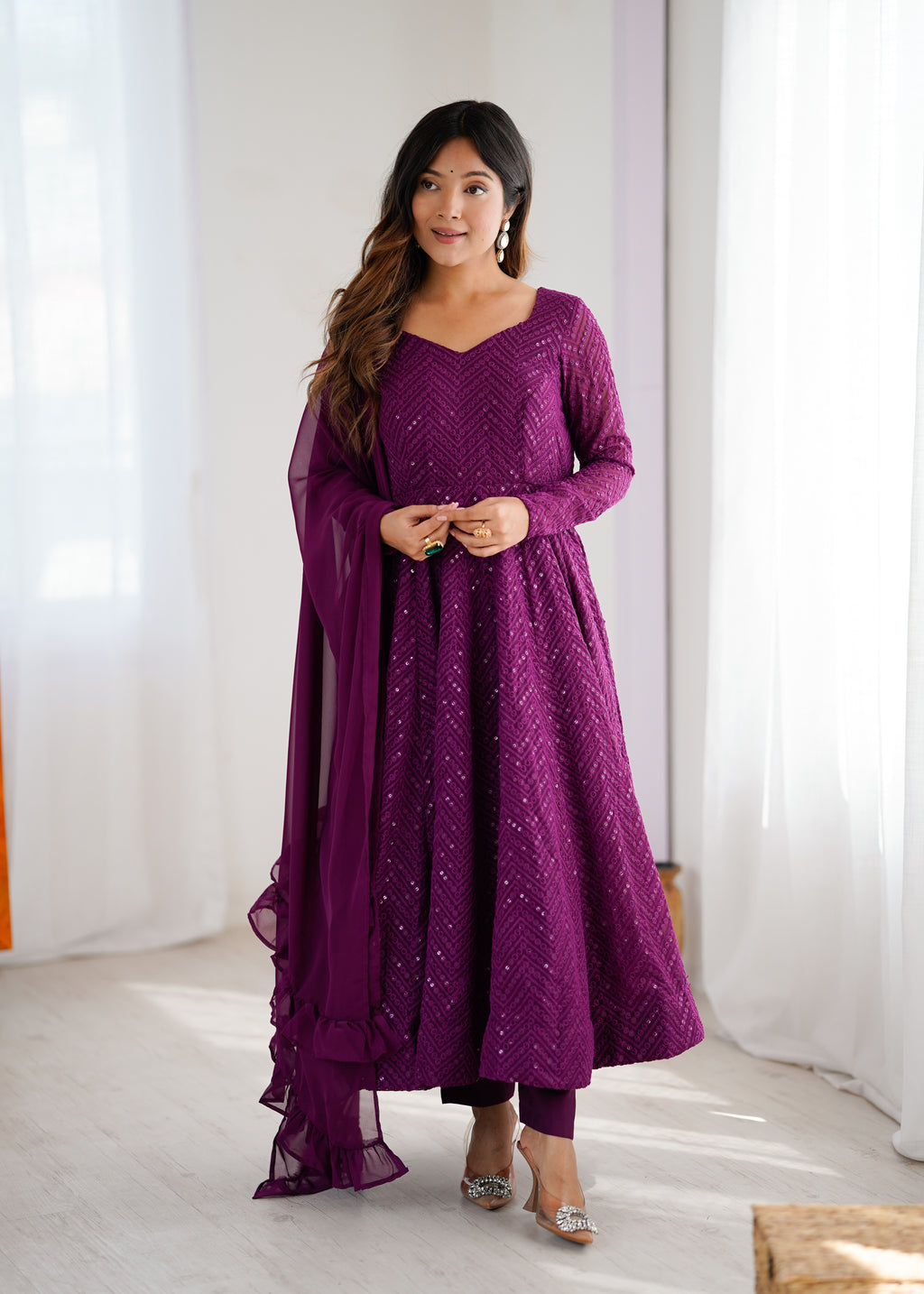 Woman wearing a purple traditional outfit with a white background
