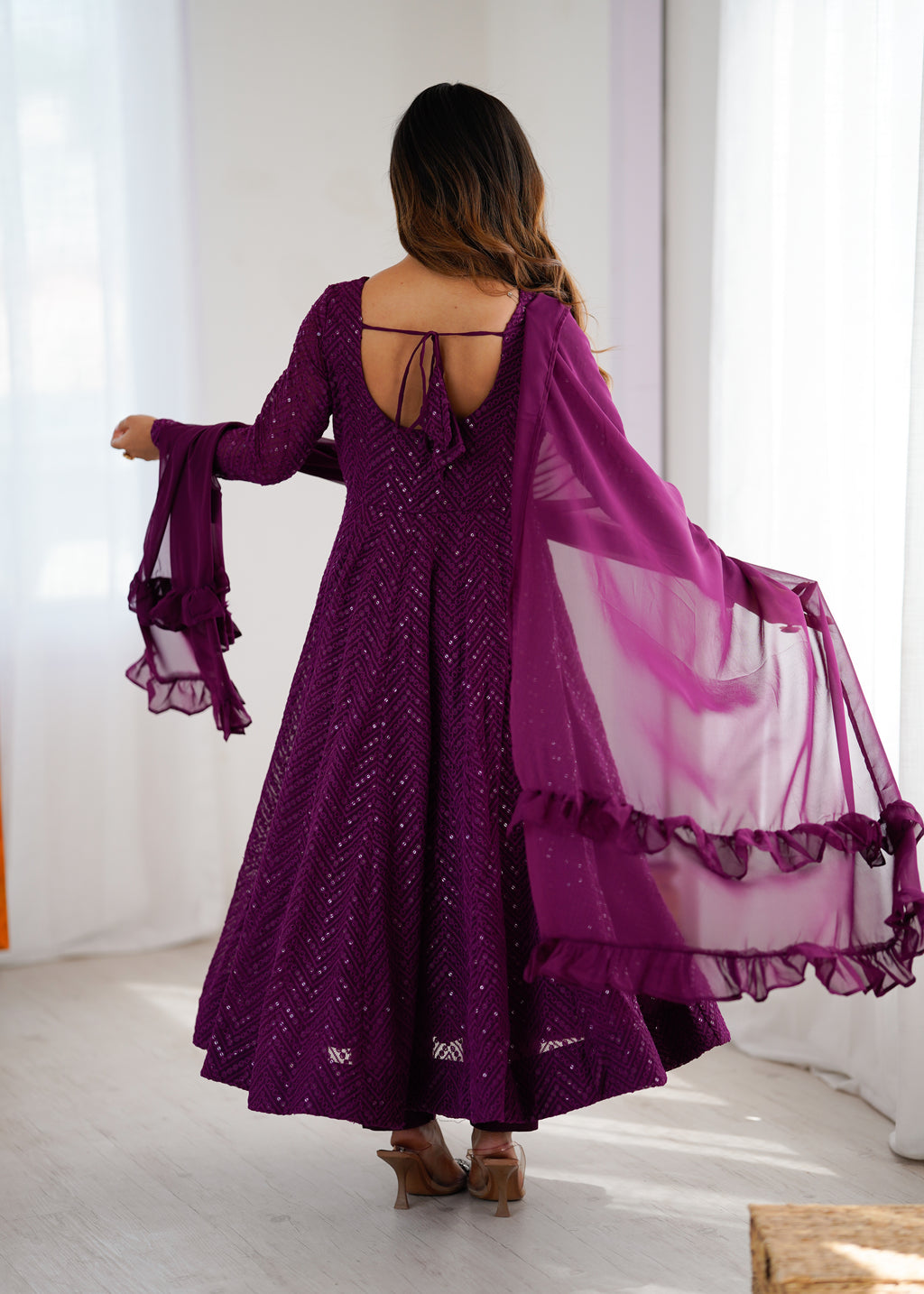 Woman in a purple dress with a matching dupatta in a bright room