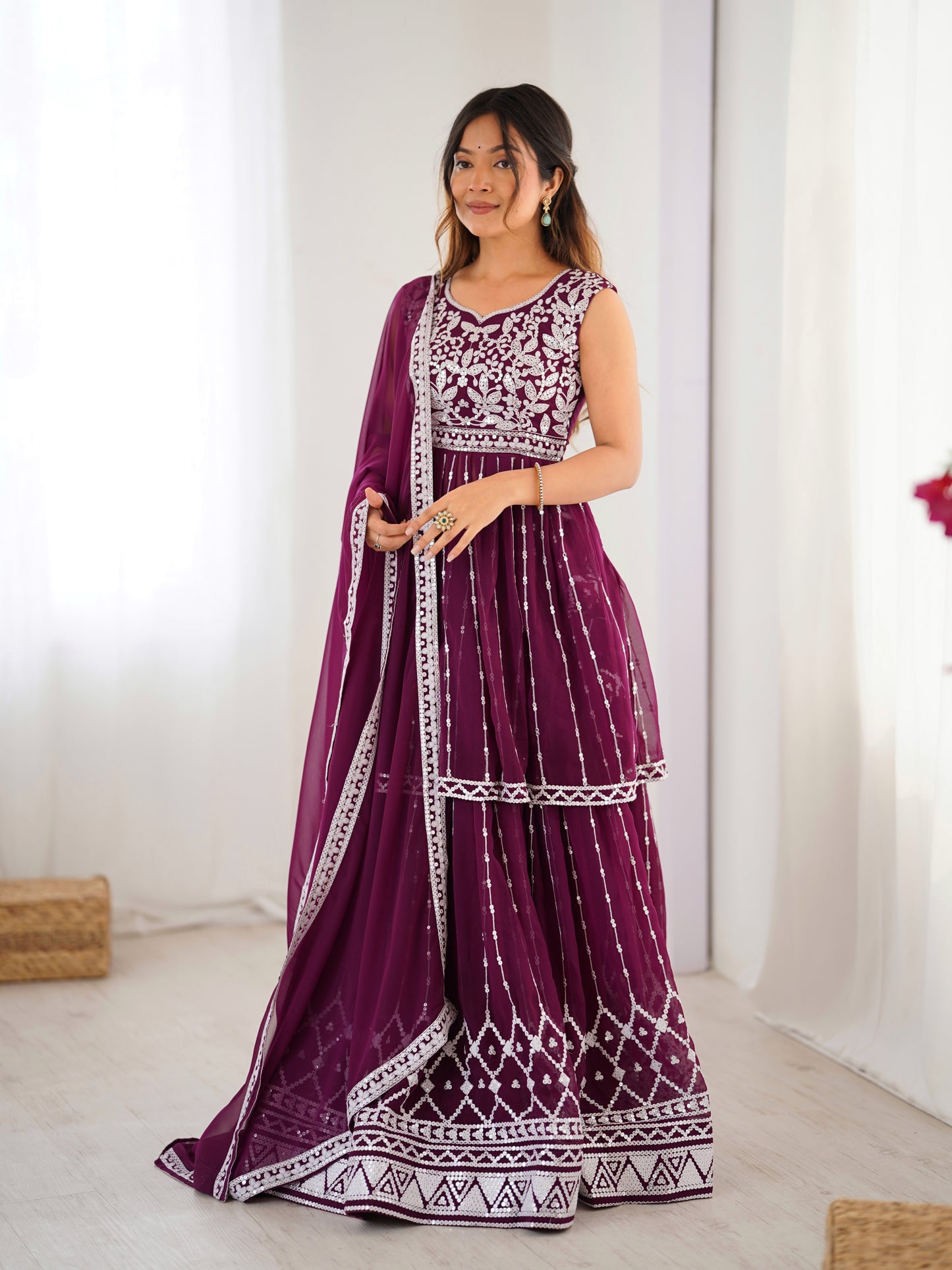 Woman wearing a purple and white patterned dress with a matching dupatta indoors.