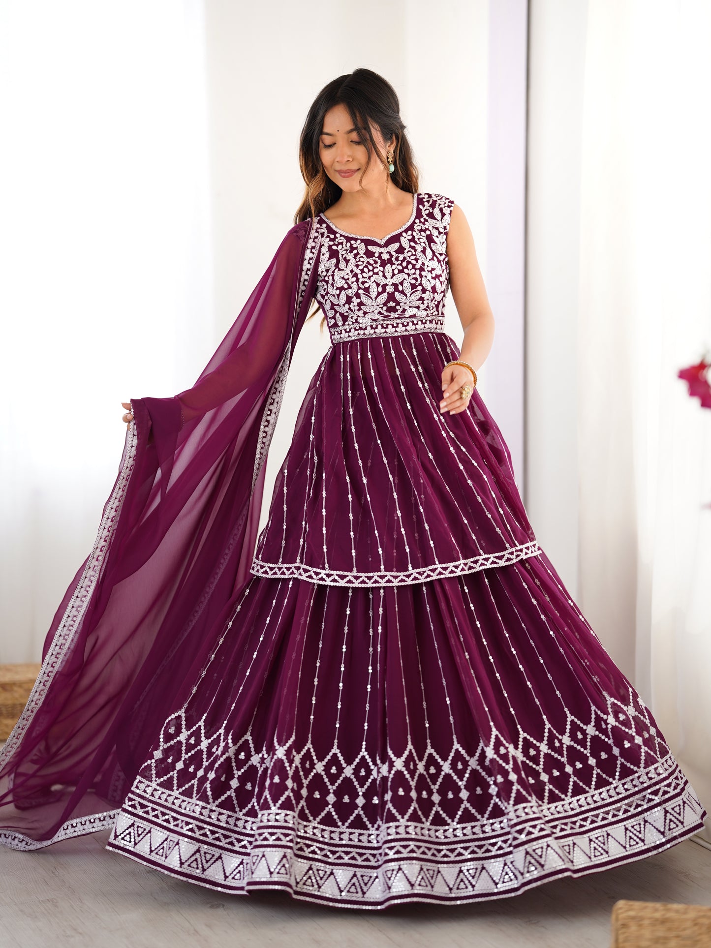 Woman wearing a purple and white embroidered traditional dress with a dupatta.