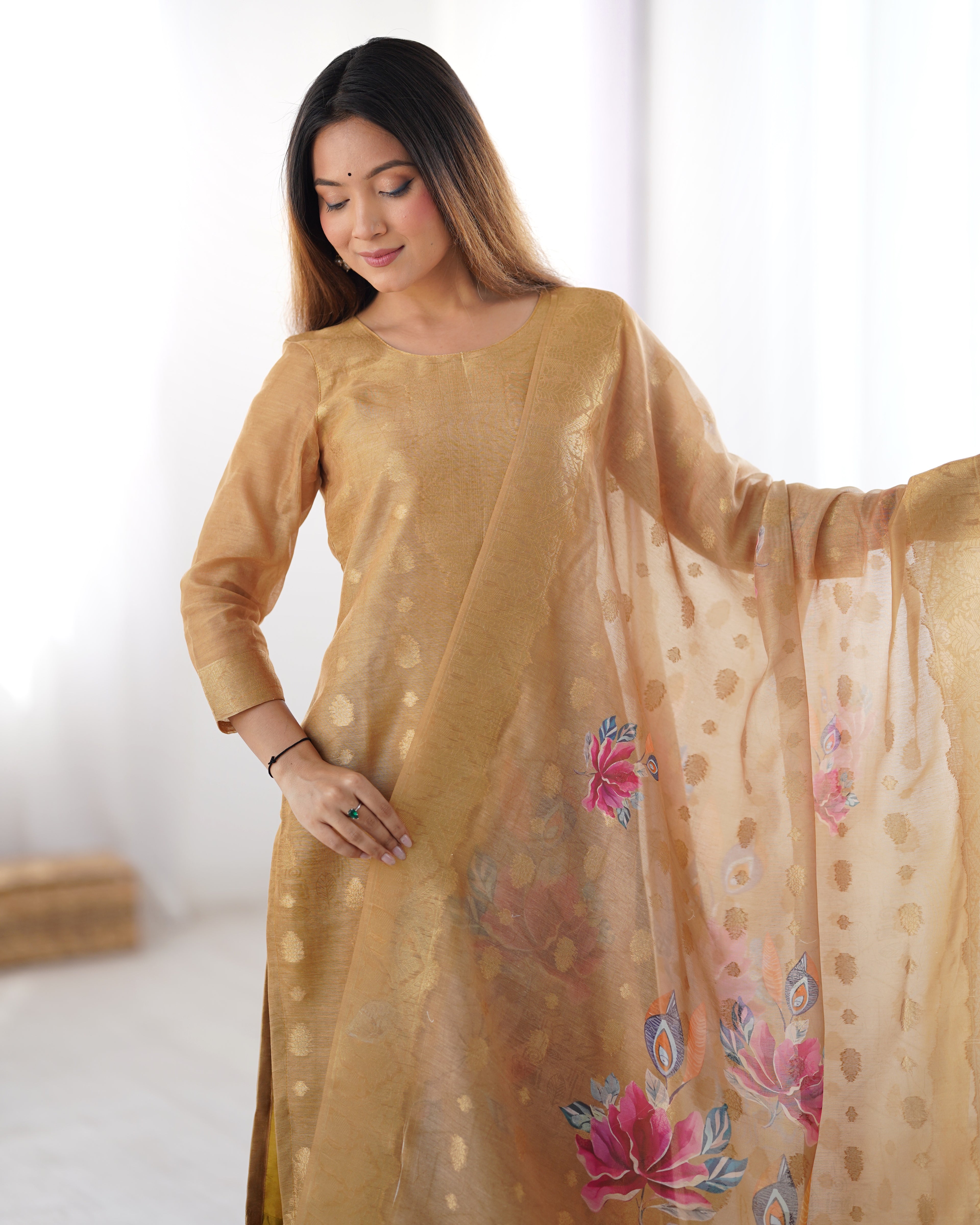 Woman wearing a beige traditional outfit with a floral dupatta against a white background