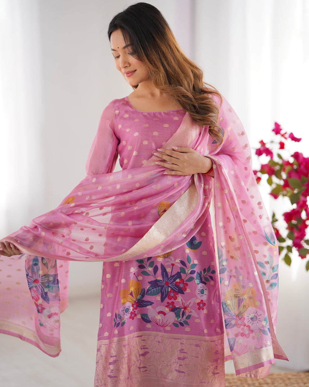Woman holding a pink floral saree with a white background