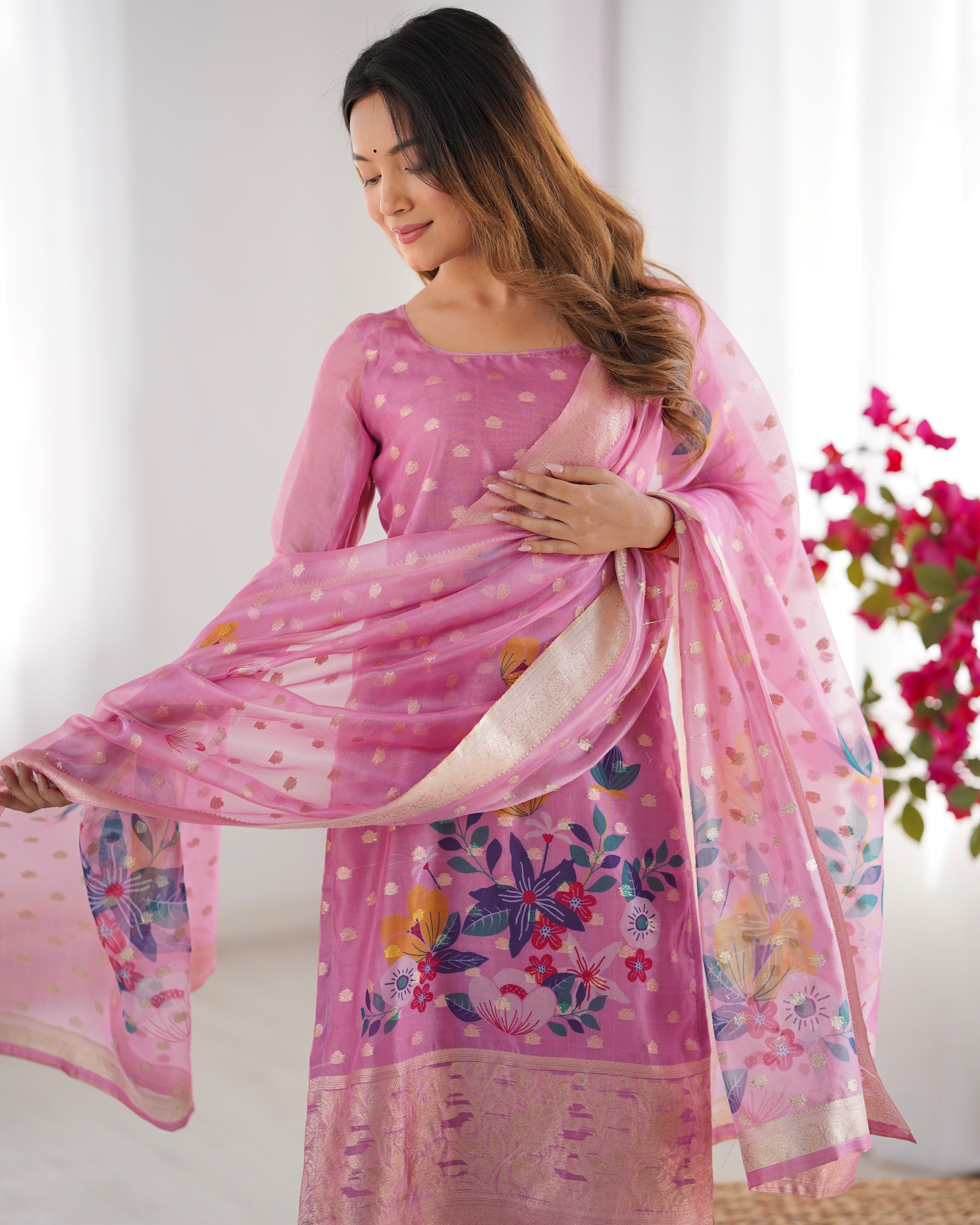 Woman holding a pink floral saree with a white background