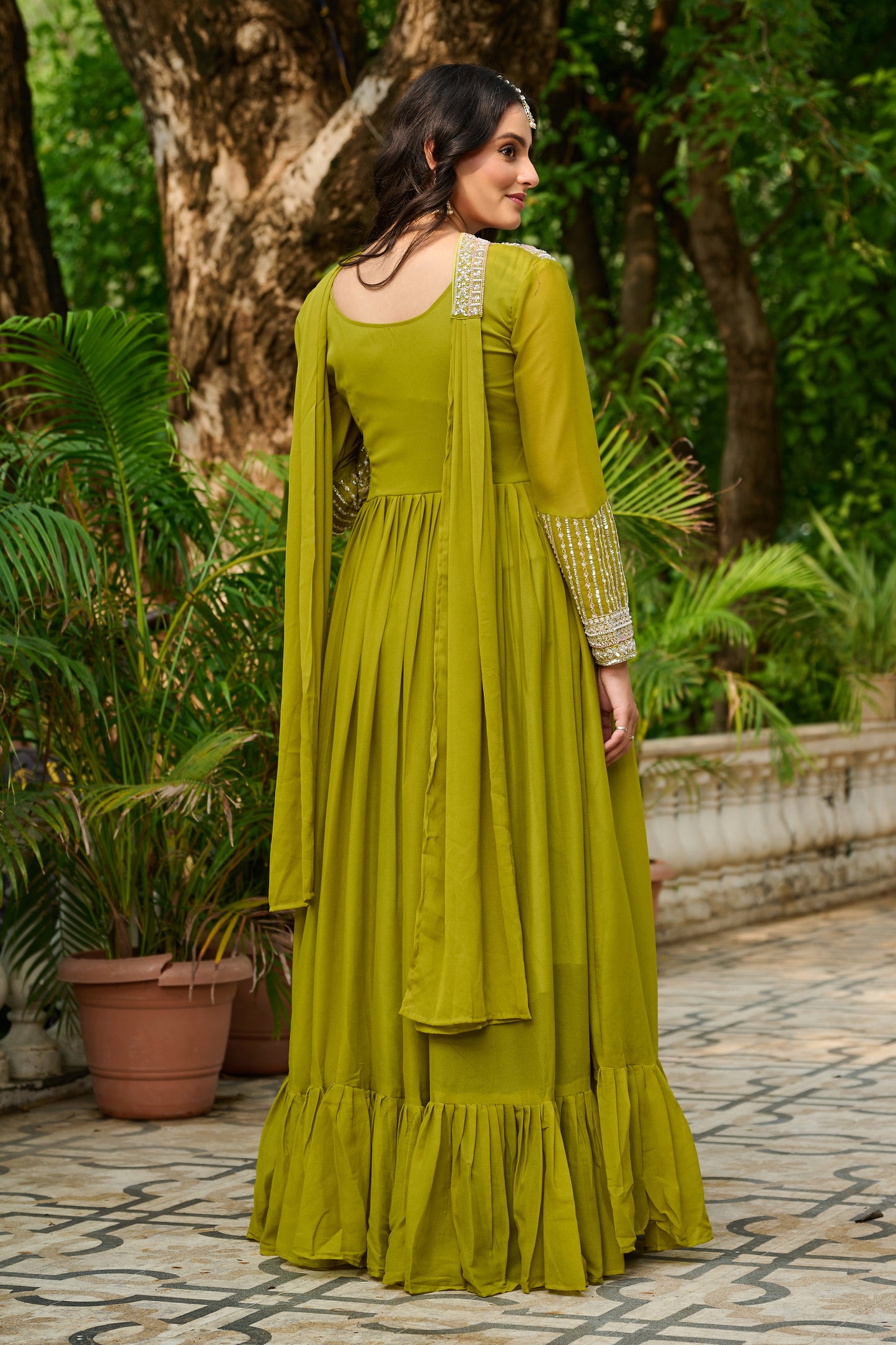 Woman in a green dress standing in a garden setting