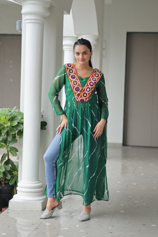 Woman wearing a green dress with a colorful pattern standing in front of a white column.