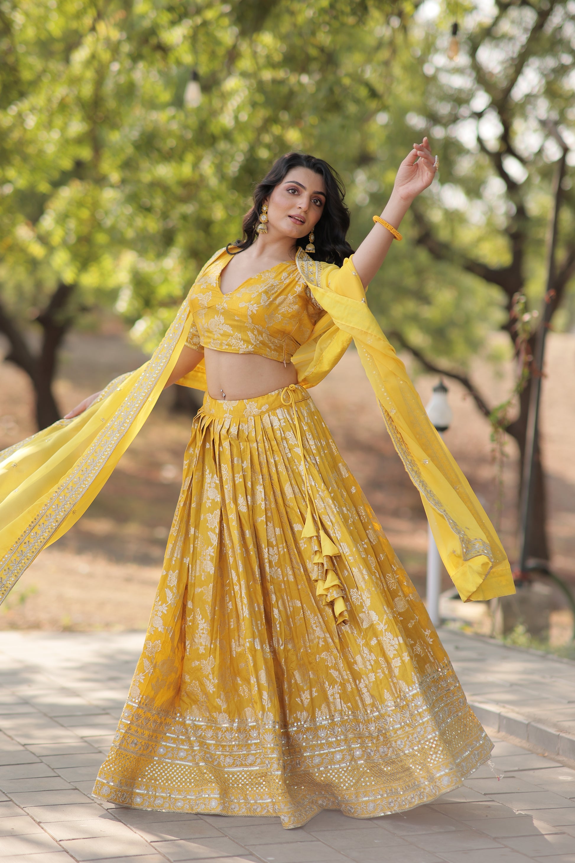 Woman in a yellow dress standing outdoors with trees in the background