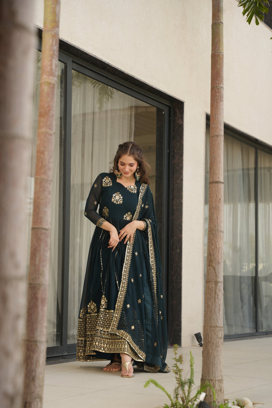 Woman wearing a dark blue embroidered dress standing in front of a mirror.