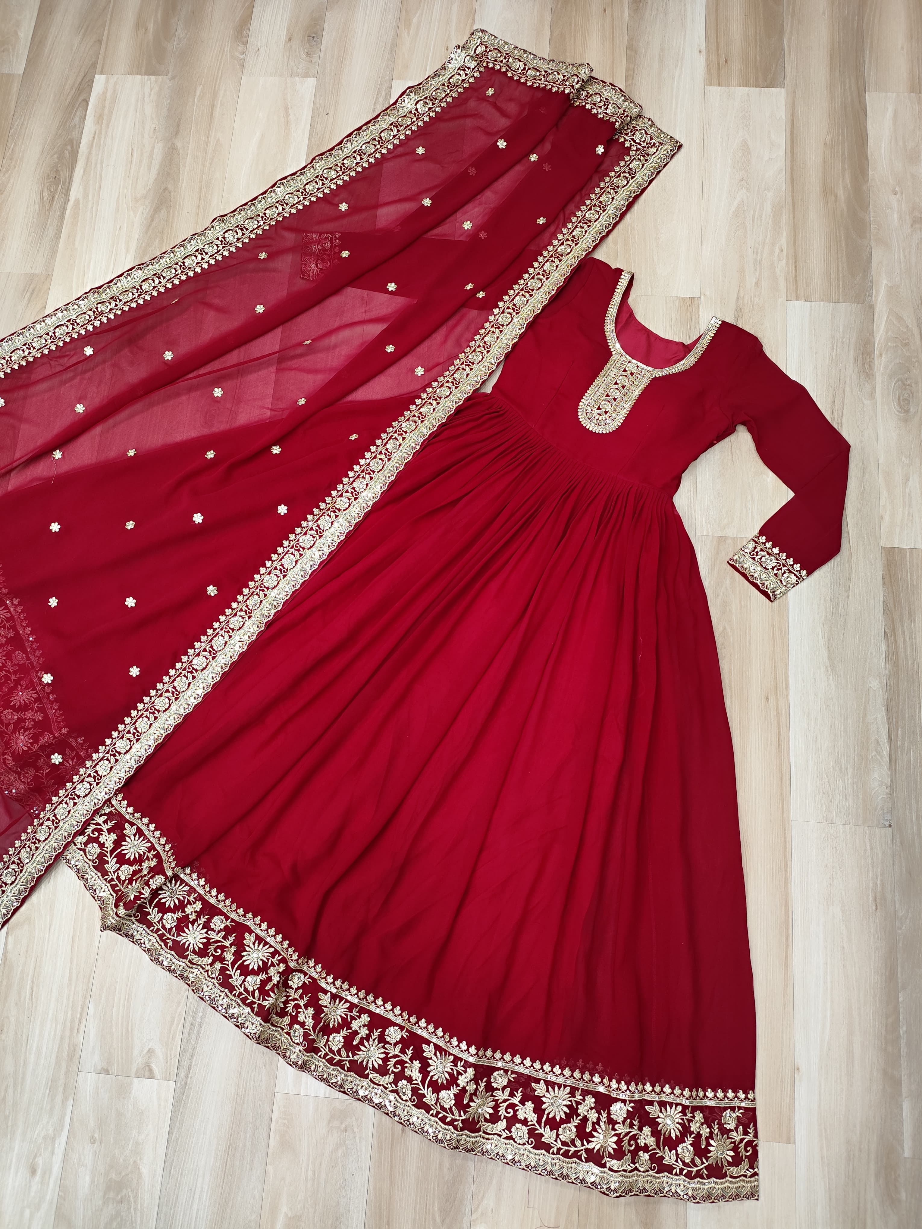 Red traditional outfit with matching dupatta on a wooden floor